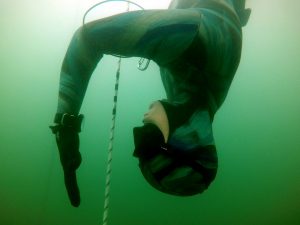freediver looks at the freediving watch at depth
